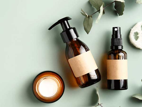 Automatización industrial en el sector cosmético con frascos de vidrio y productos de cuidado personal.